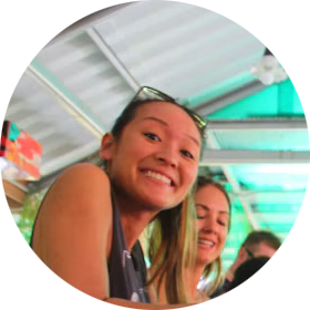 Two travellers grinning at the camera on a boat.