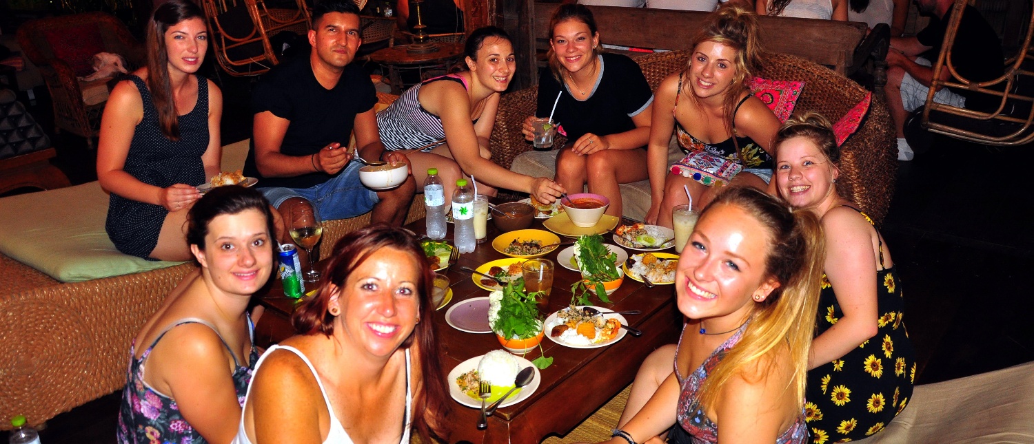 Backpacking group sharing drinks and snacks around a table at a lively bar
