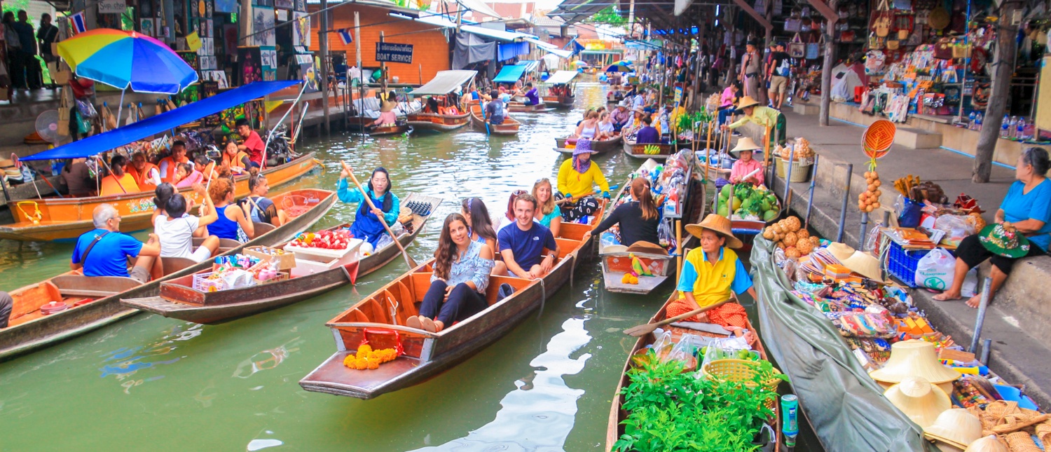 Colorful boats selling goods at Amphawa Floating Market along the canal
