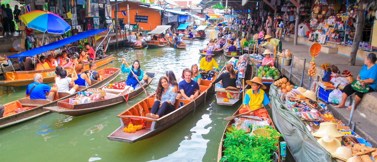 Colorful boats selling goods at Amphawa Floating Market along the canal