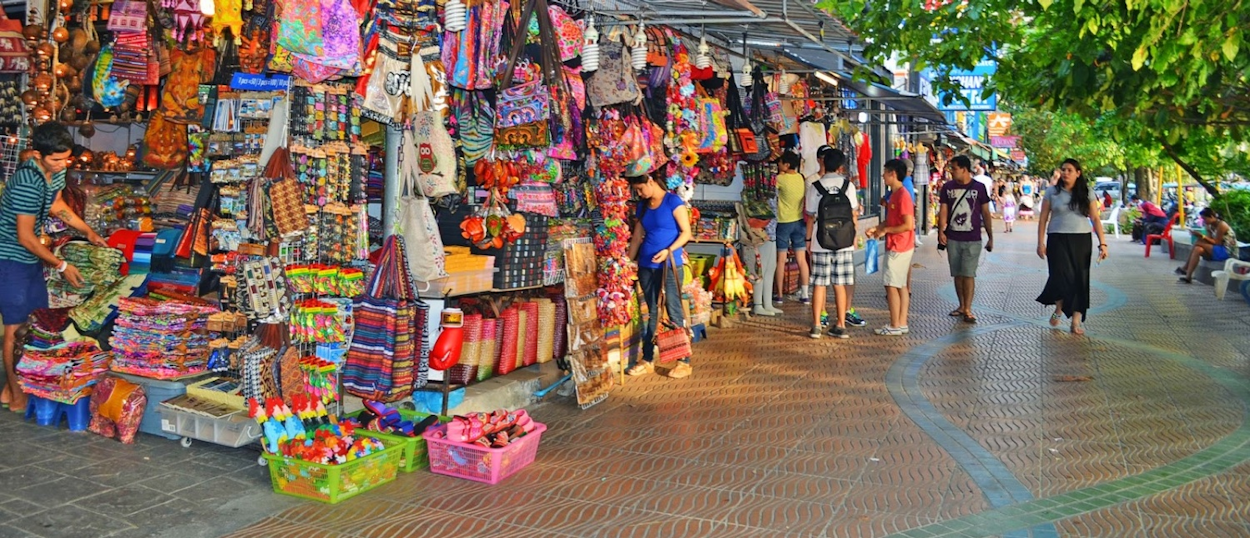 Backpacking group exploring the colorful Ao Nang night market with food and souvenir stalls