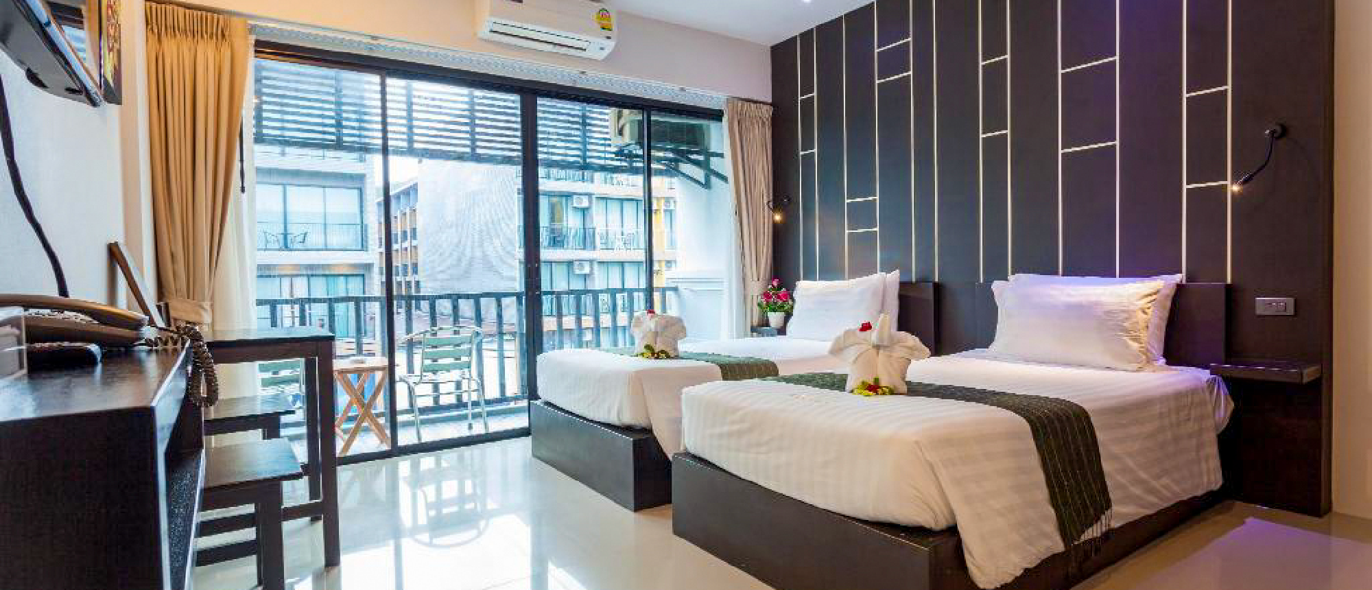 Modern hotel room with a large bed and floor-to-ceiling windows in Ao NangBackpacking group swimming and relaxing in an emerald-green river surrounded by lush jungle during a mangrove kayak adventure