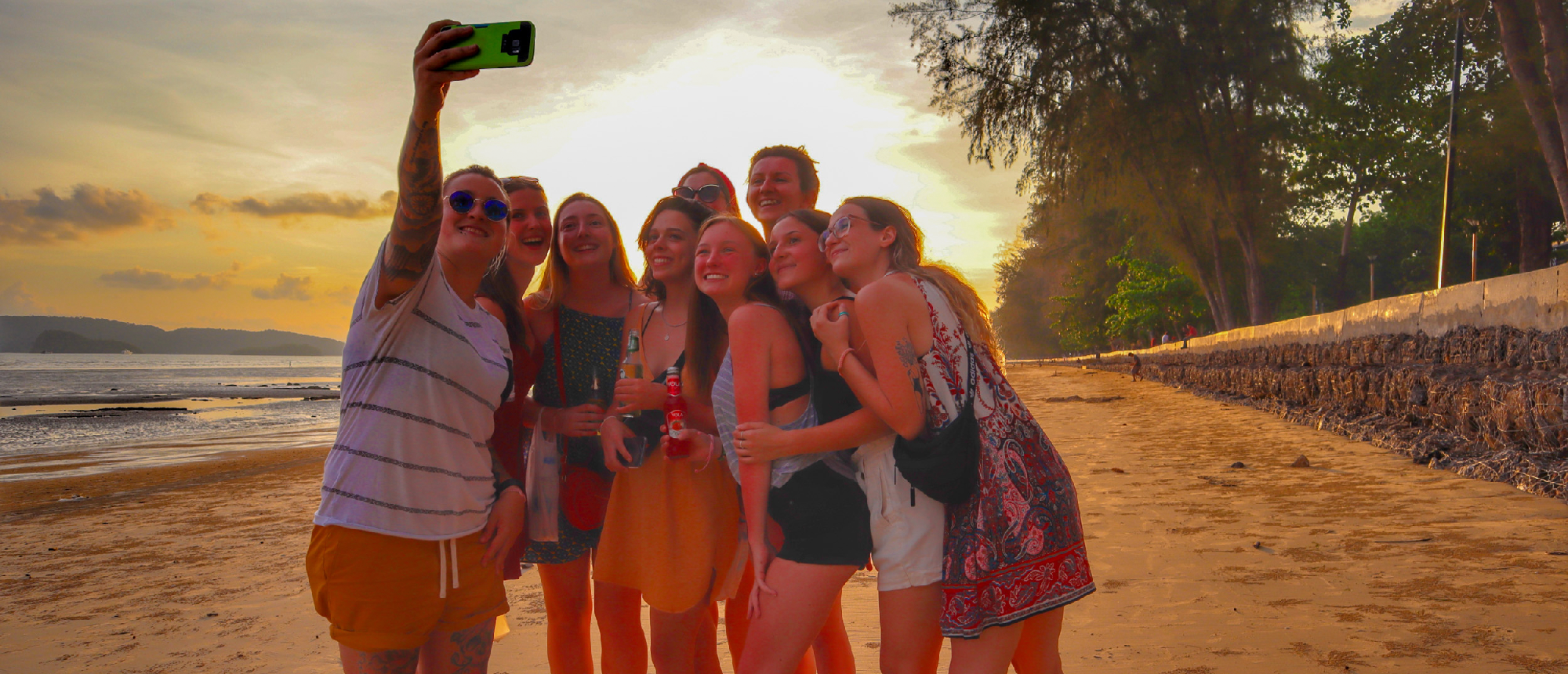 Backpacking group walking on Ao Nang Beach at sunset