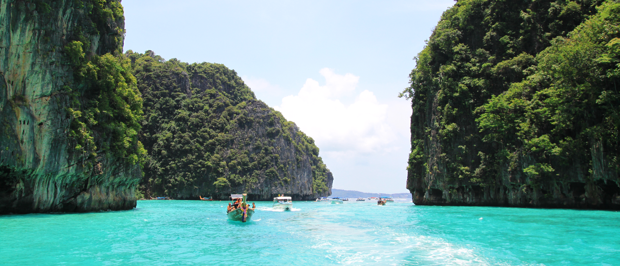 Scenic turquoise water passage between lush limestone cliffs