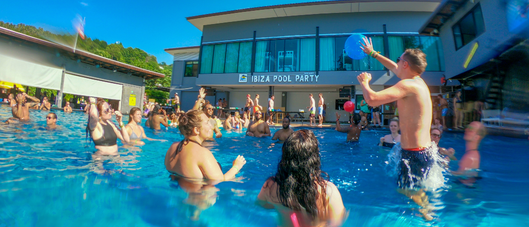 Backpacking group enjoying a pool party in the hostel swimming pool