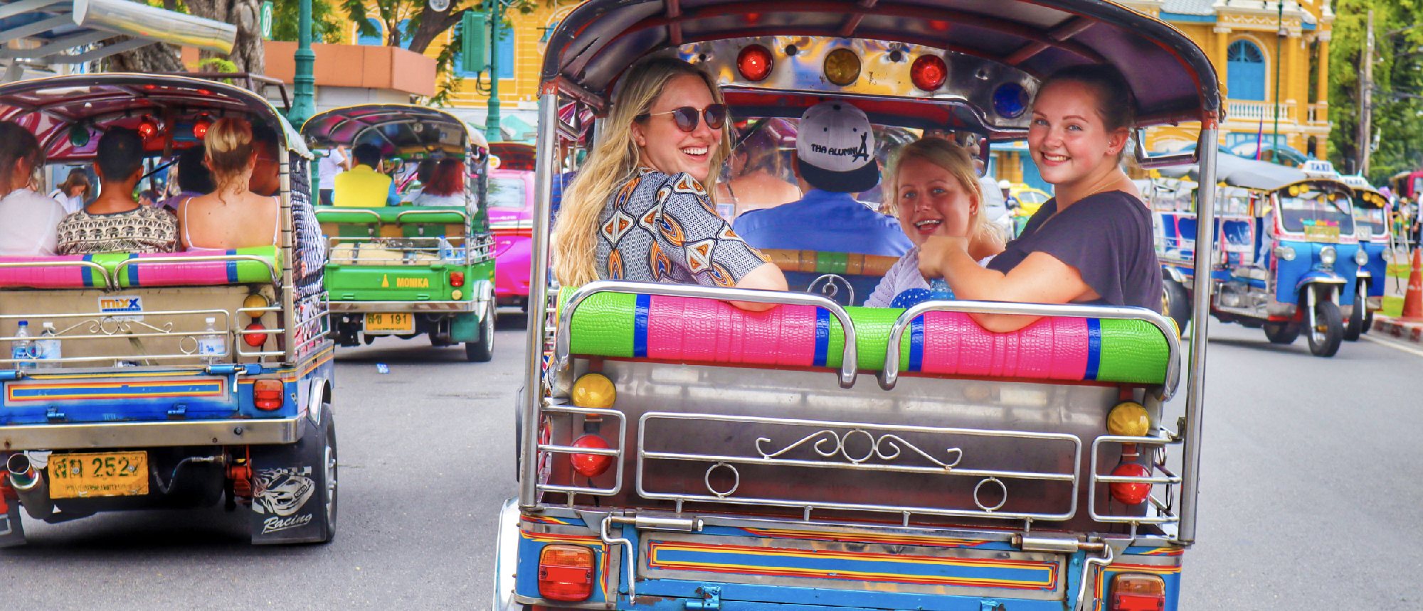 Colorful tuk-tuks on a busy Bangkok street