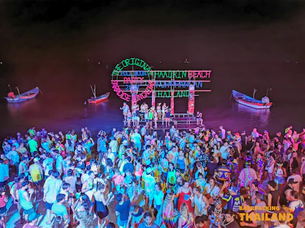 A large crowd dancing at the vibrant Full Moon Party on Haad Rin Beach, Thailand.