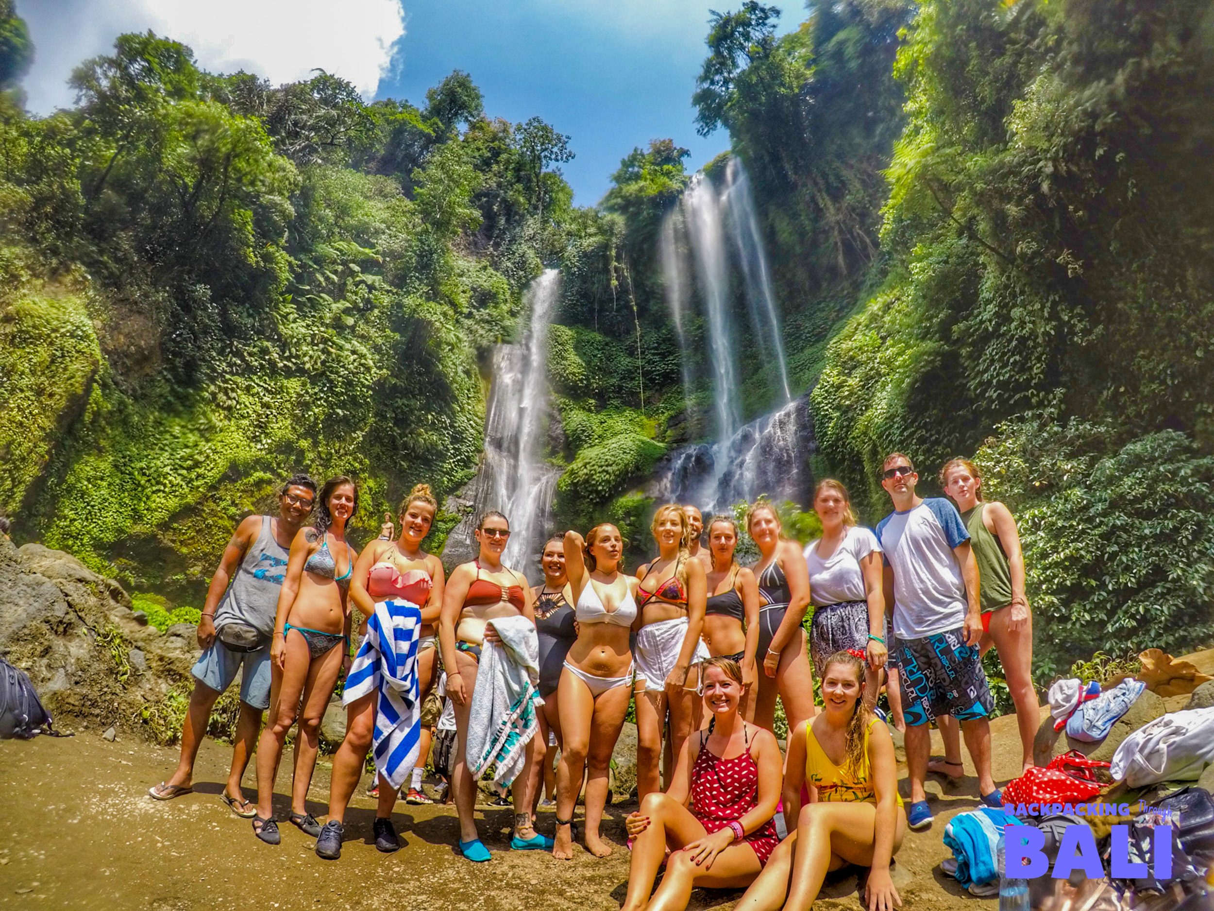 Backpacking group posing in front of Sekumpul Waterfalls
