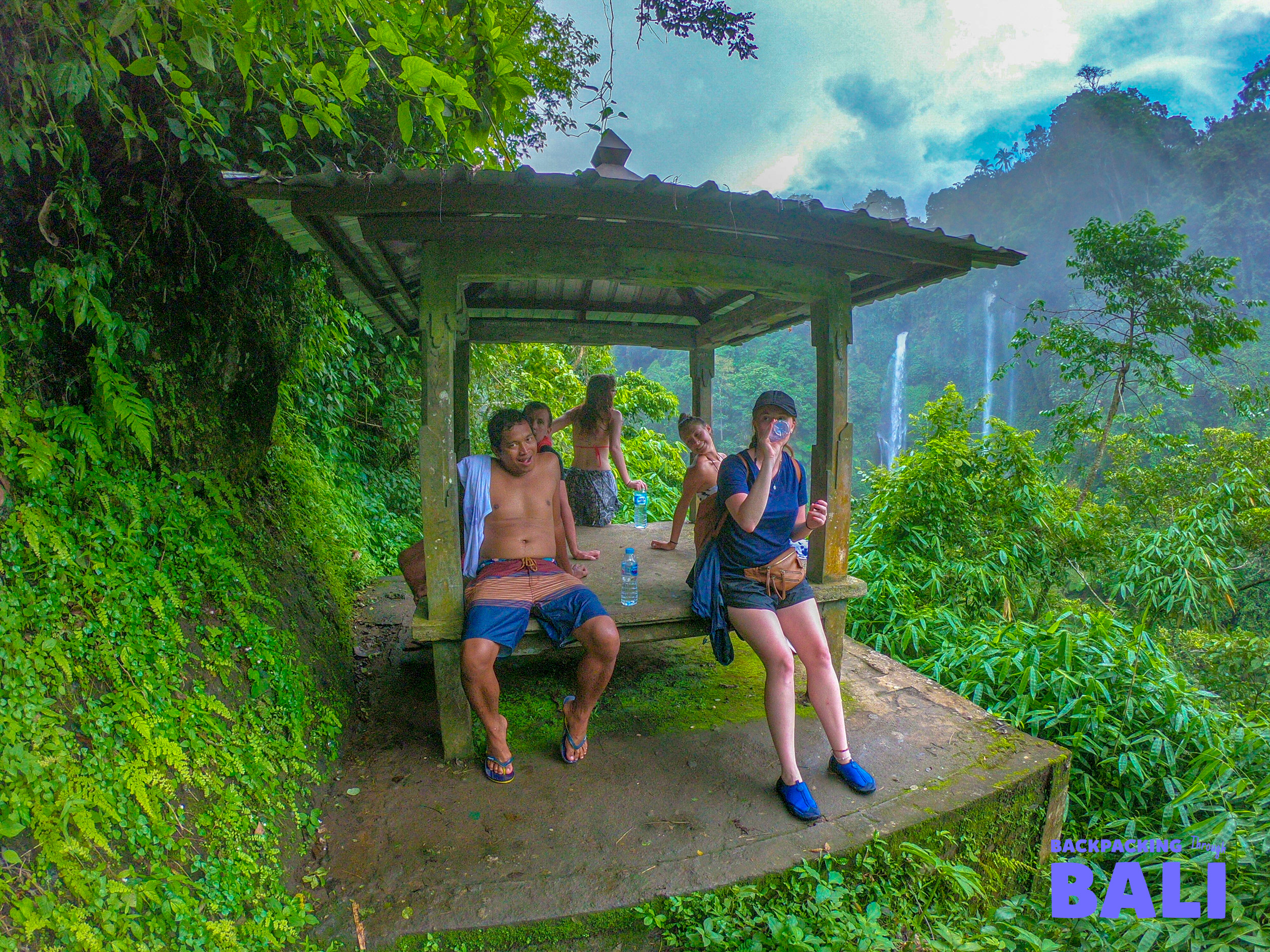 Two travellers resting at a shelter by rice terraces