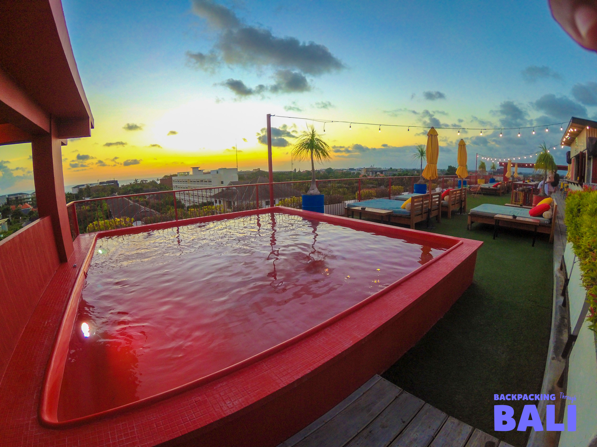 Traveller raising arms on the deck of a boat at sunset in Bali
