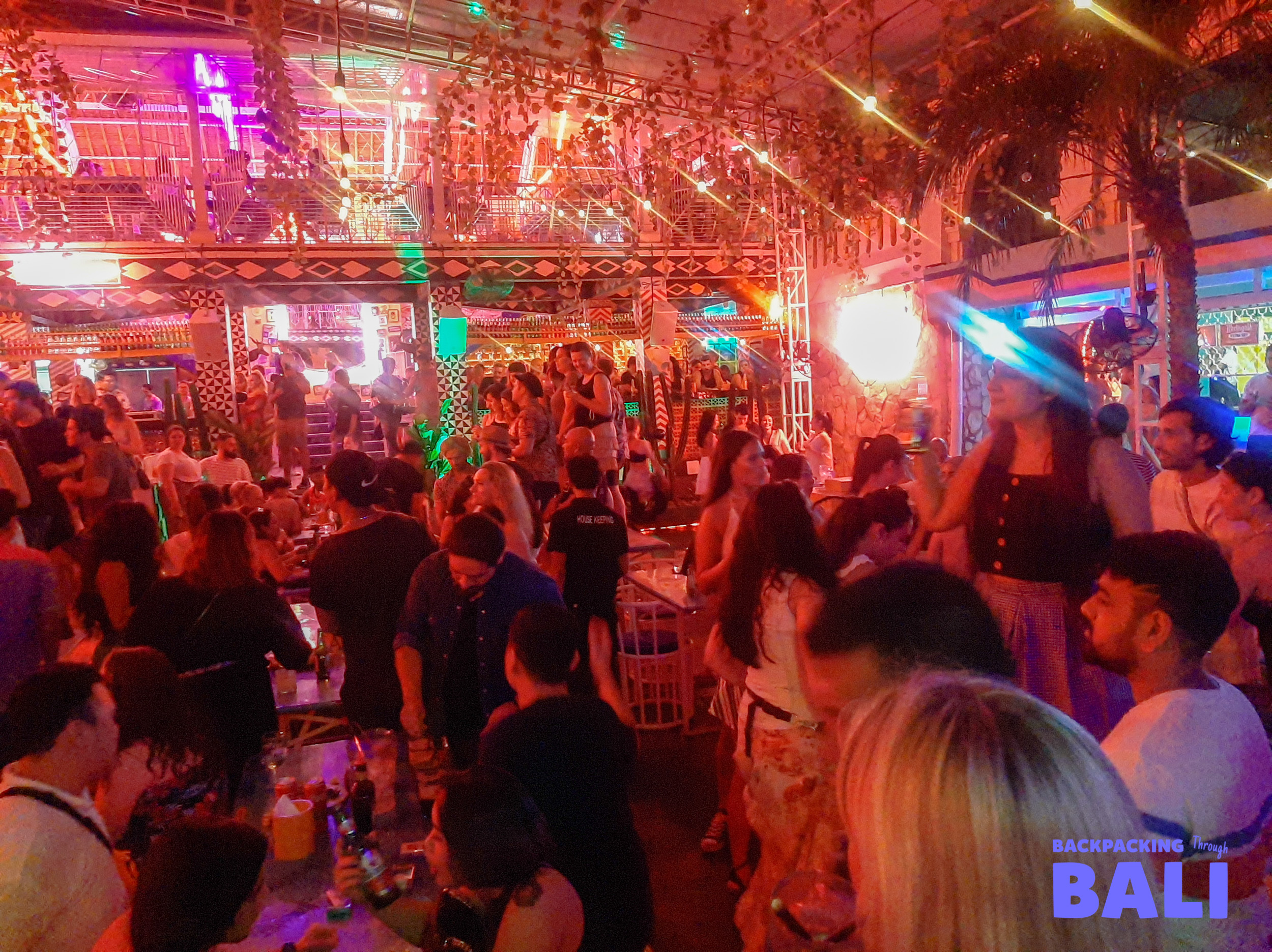 Crowd dancing under colourful lights at a nightclub in Bali
