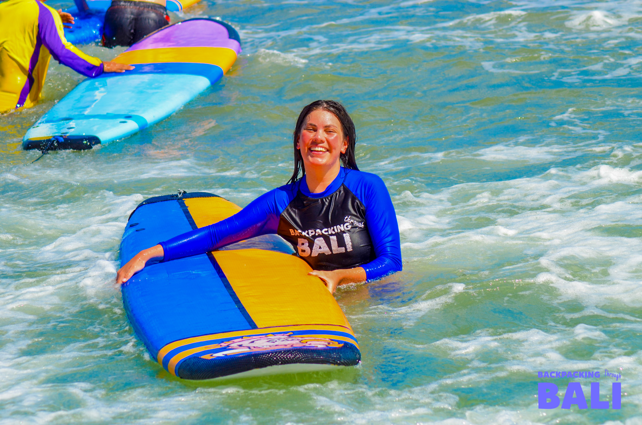 Female traveler enjoying a surfing lesson on a foam board in Bali
