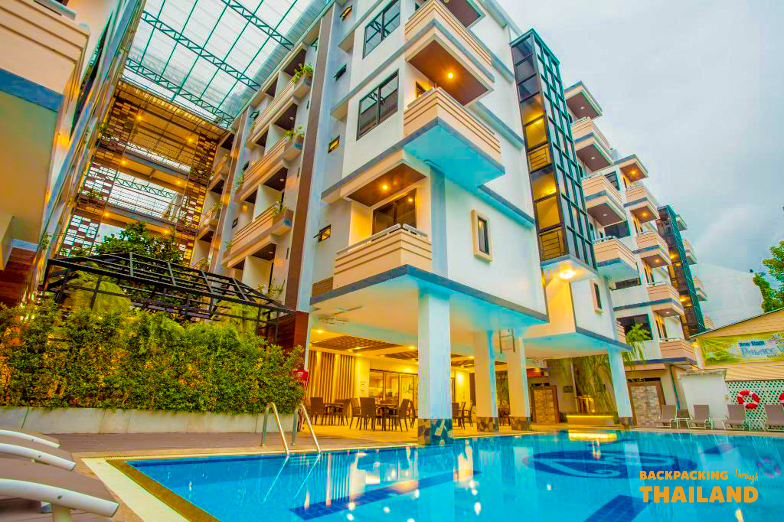 Colorful hotel building with balconies and an outdoor swimming pool in Bangkok