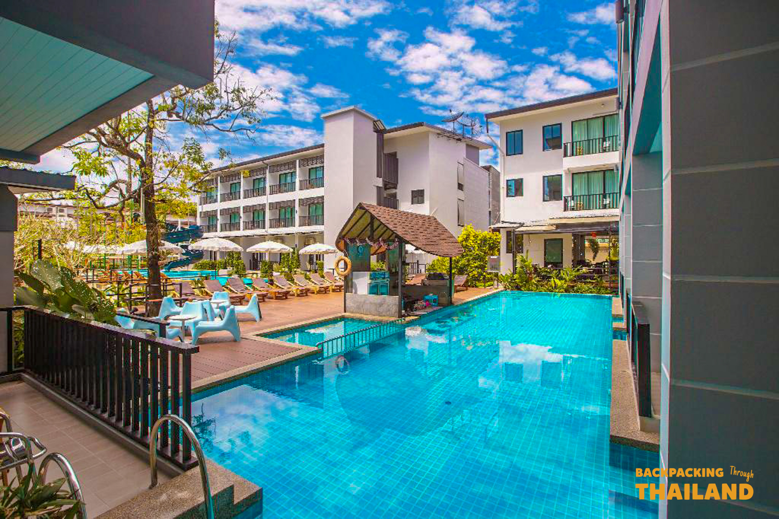 Colourful patterned roof and walkway above a turquoise hotel pool with multi-story buildings, Day 9 accommodationBird's-eye view ofTurquoise hotel pool surrounded by multi-story buildings and colourful roof walkway, Day 9 accommodationBirds-eye view of modern hotel buildings surrounding a turquoise swimming pool with lush greenery, Day 9 accommodationBirds-eye view of modern hotel buildings surrounding a turquoise swimming pool with lush greenery, Day 9 accommodationhotel buildings and turquoise swimming pool with lush greenery, Day 9 accommodation