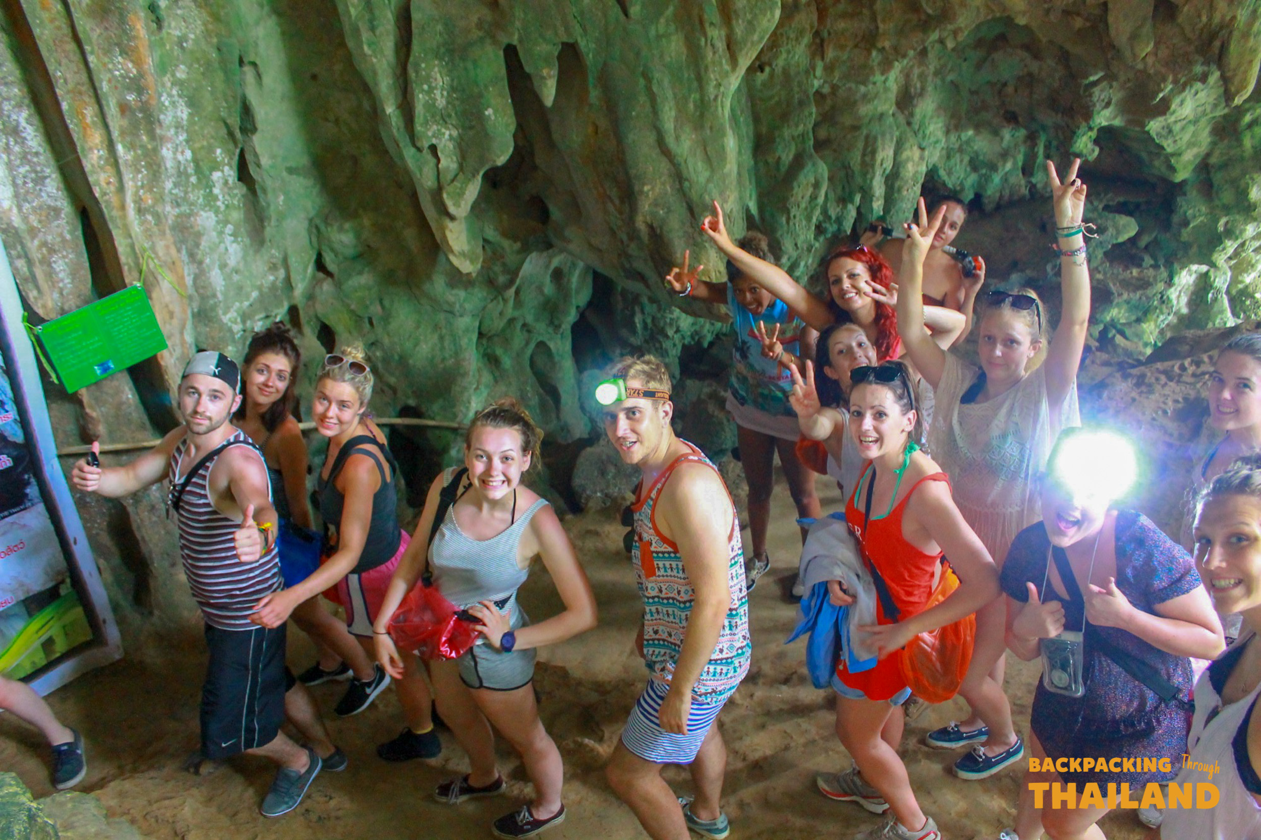 Backpackers exploring inside a limestone cave with headlamps and flashlights, Day 8 activityGroup of friends lounging on a wooden deck wearing swimwear, Day 8 activity