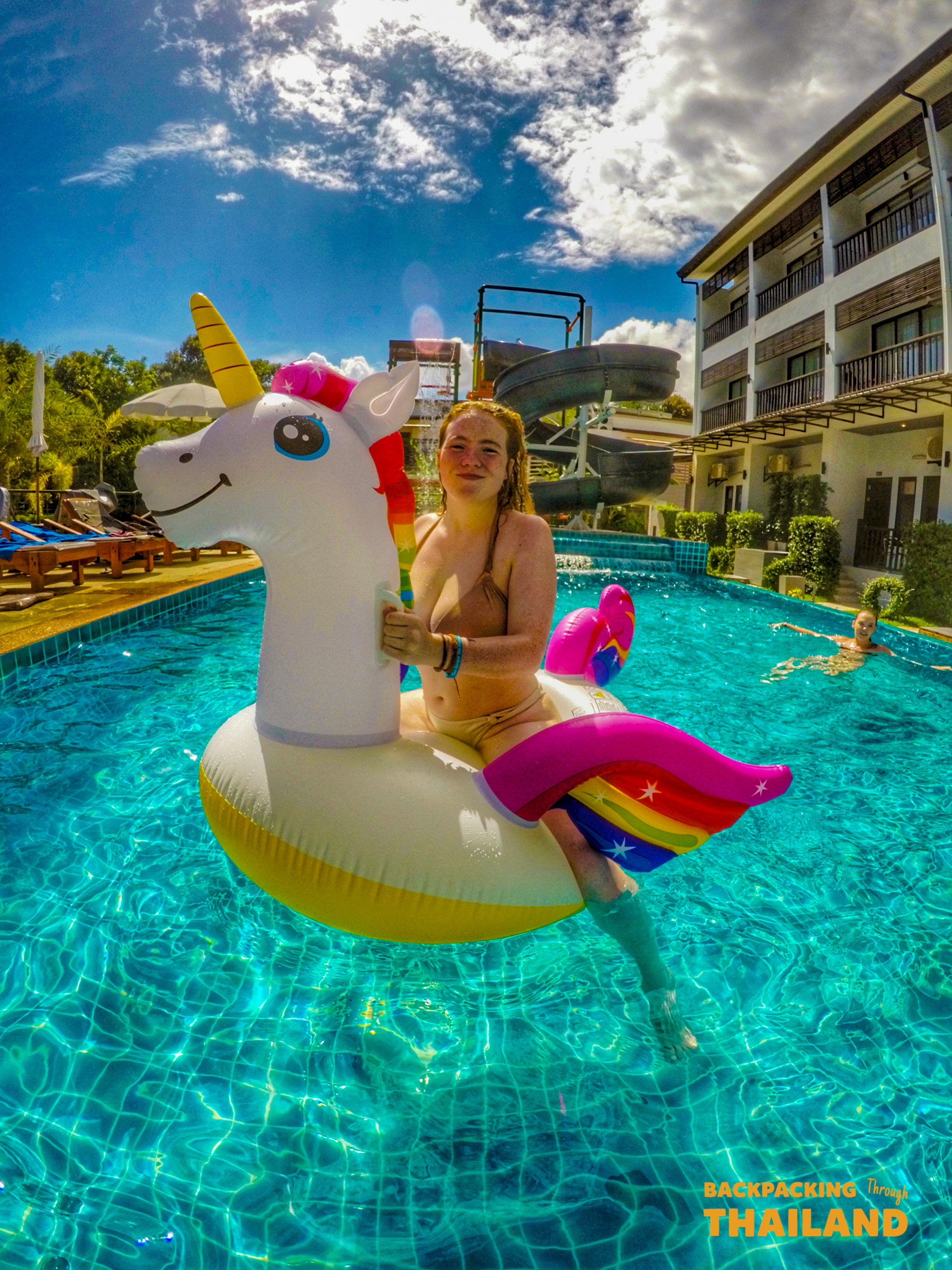 Traveller relaxing on a colourful unicorn float in a blue swimming pool at a resort, Day 9 activity