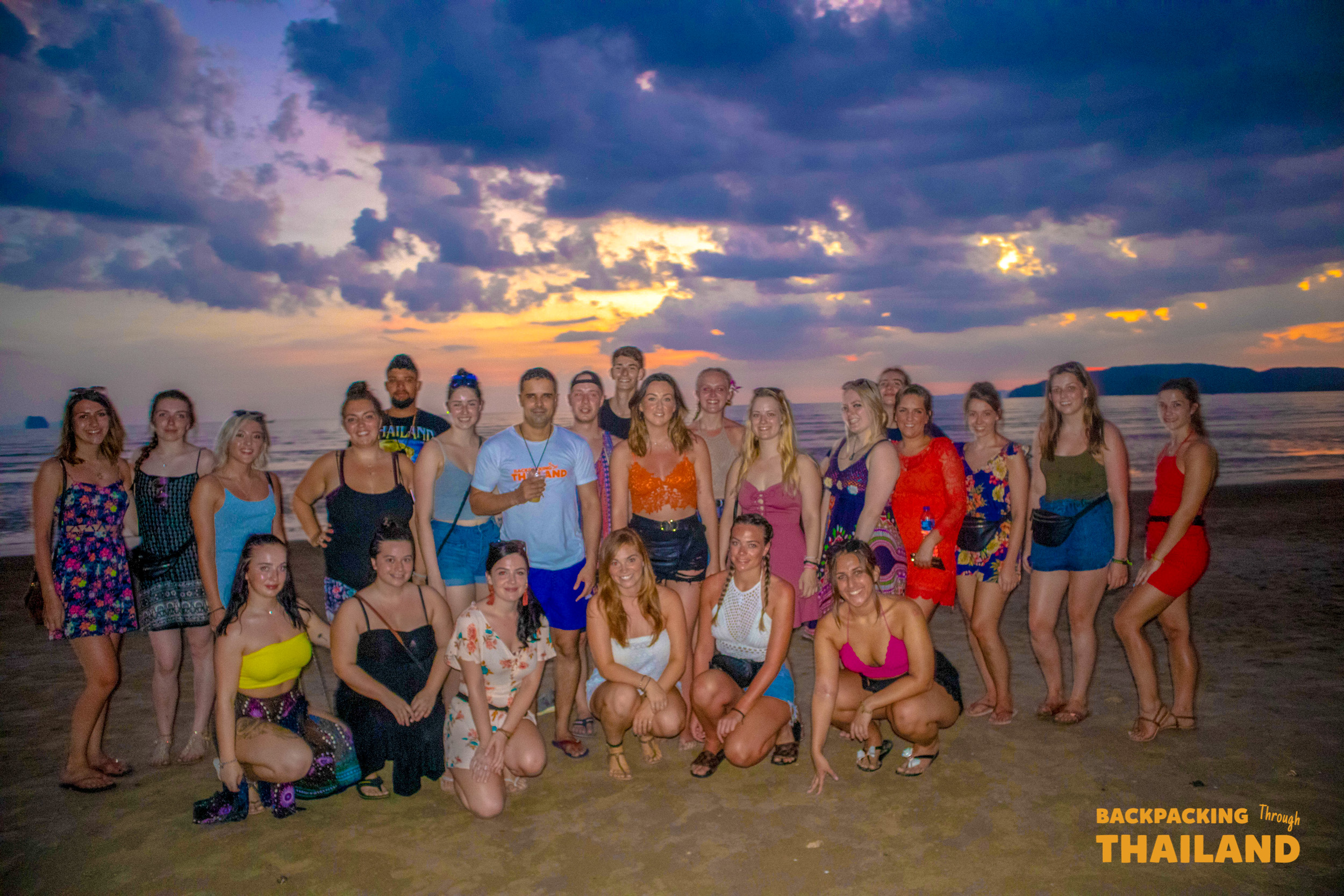 Large group of travellers posing for a group photo in front of the Krabi landmark sign at sunset, Day 9 activity