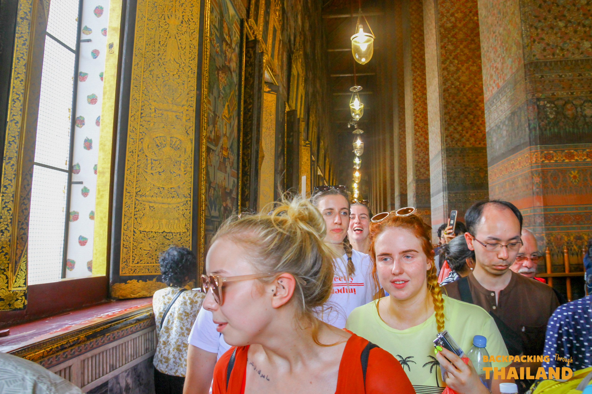 A visitor admiring the giant golden Reclining Buddha inside Wat Pho temple.