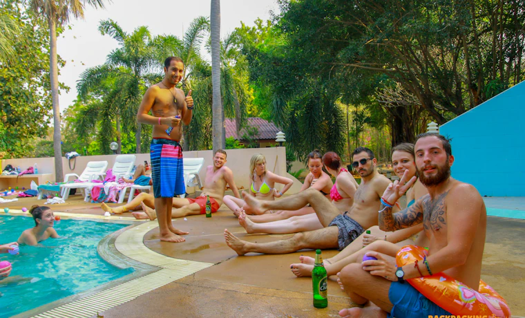 Friends enjoy a lively poolside party and drinking games at a resort in Singburi, Thailand.
