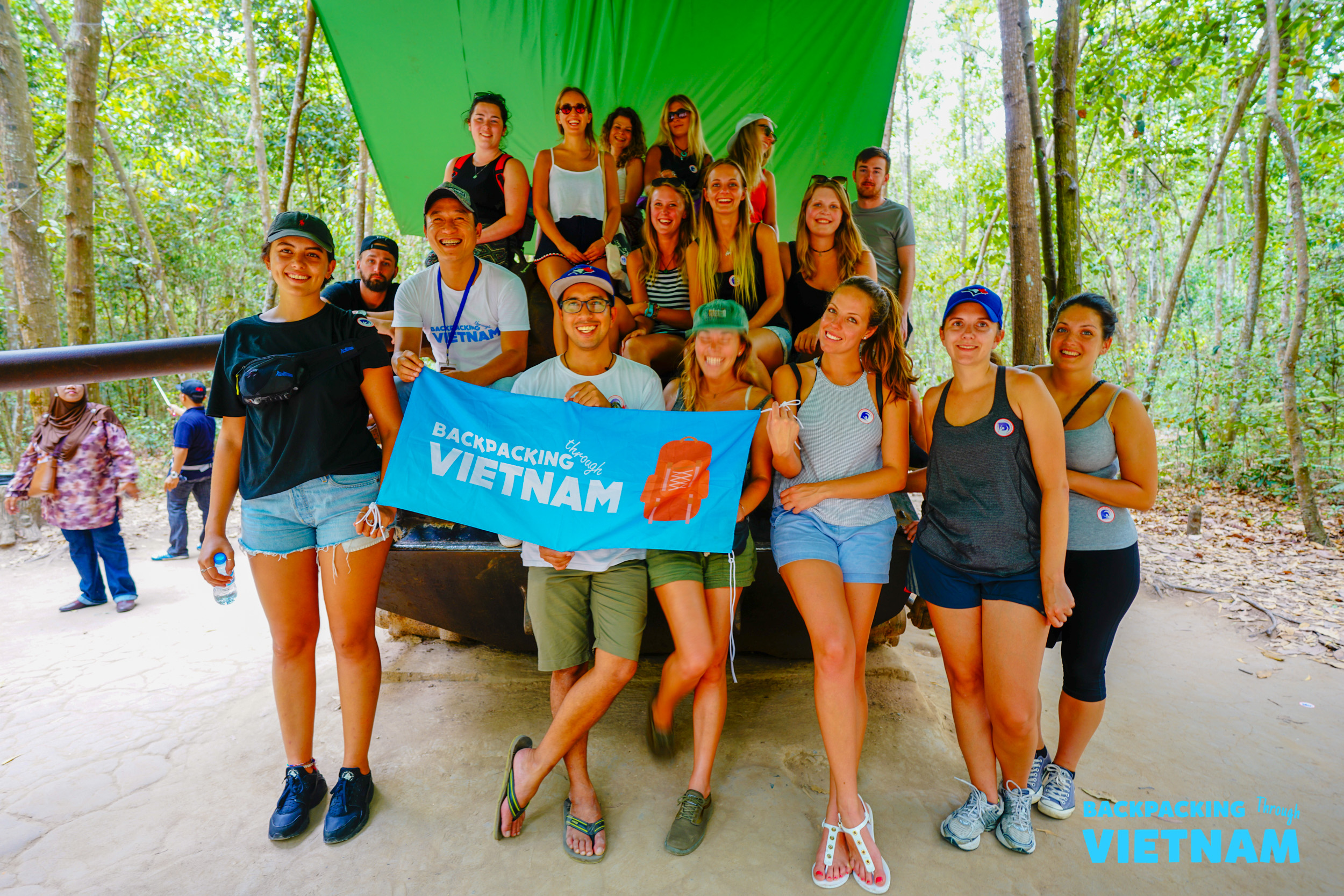 Backpacking group posing with Vietnam sign at Cu ChiBackpacking group at entrance of Cu Chi Tunnels