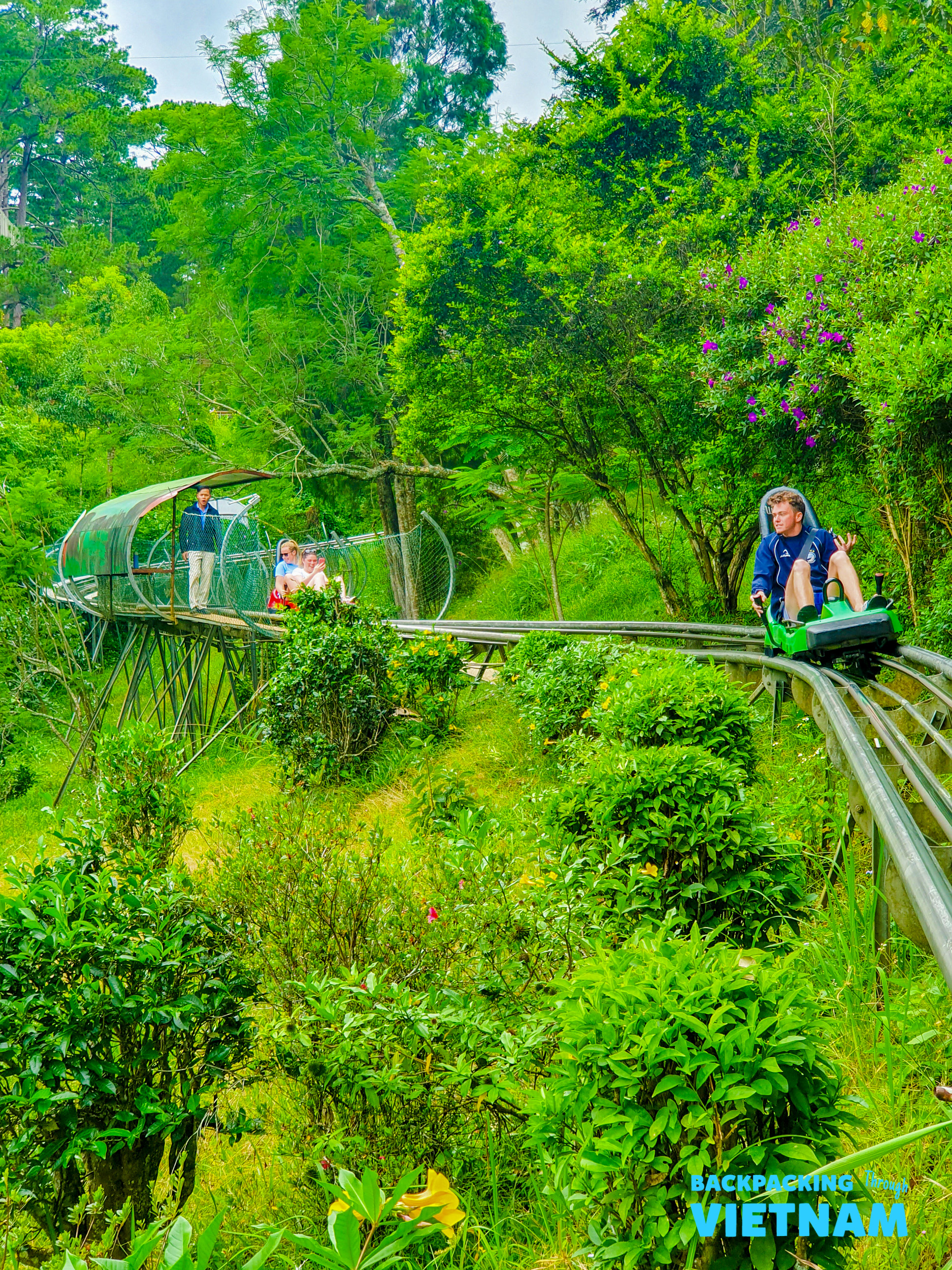 Friends riding double alpine coaster in Dalat forest