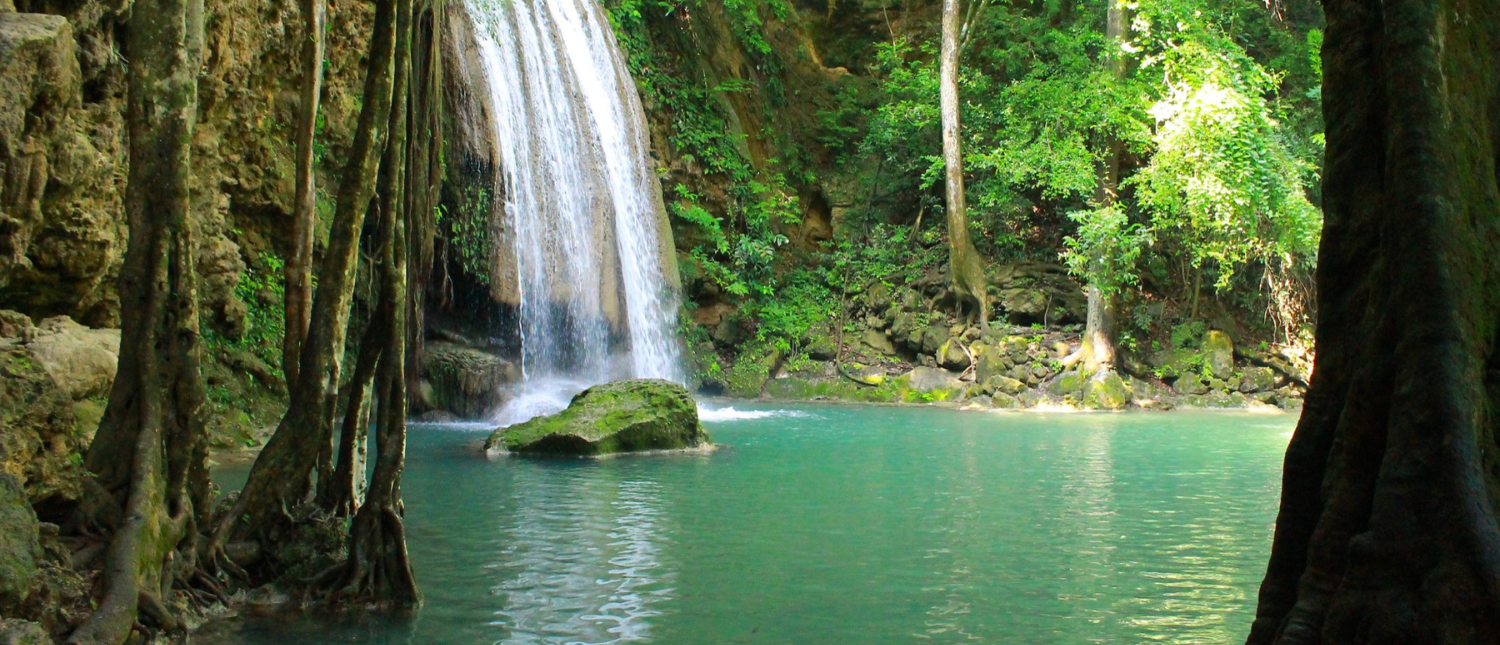 Emerald green pool and cascading waterfall at Erawan National Park