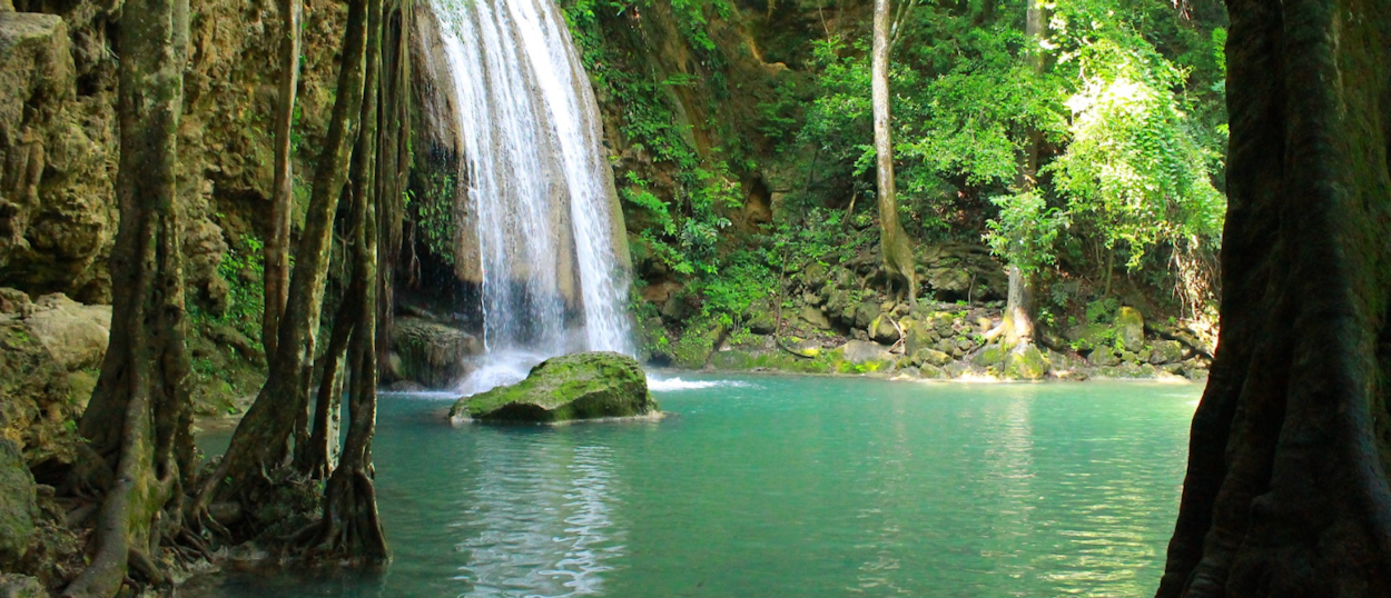 Emerald green pool and cascading waterfall at Erawan National Park