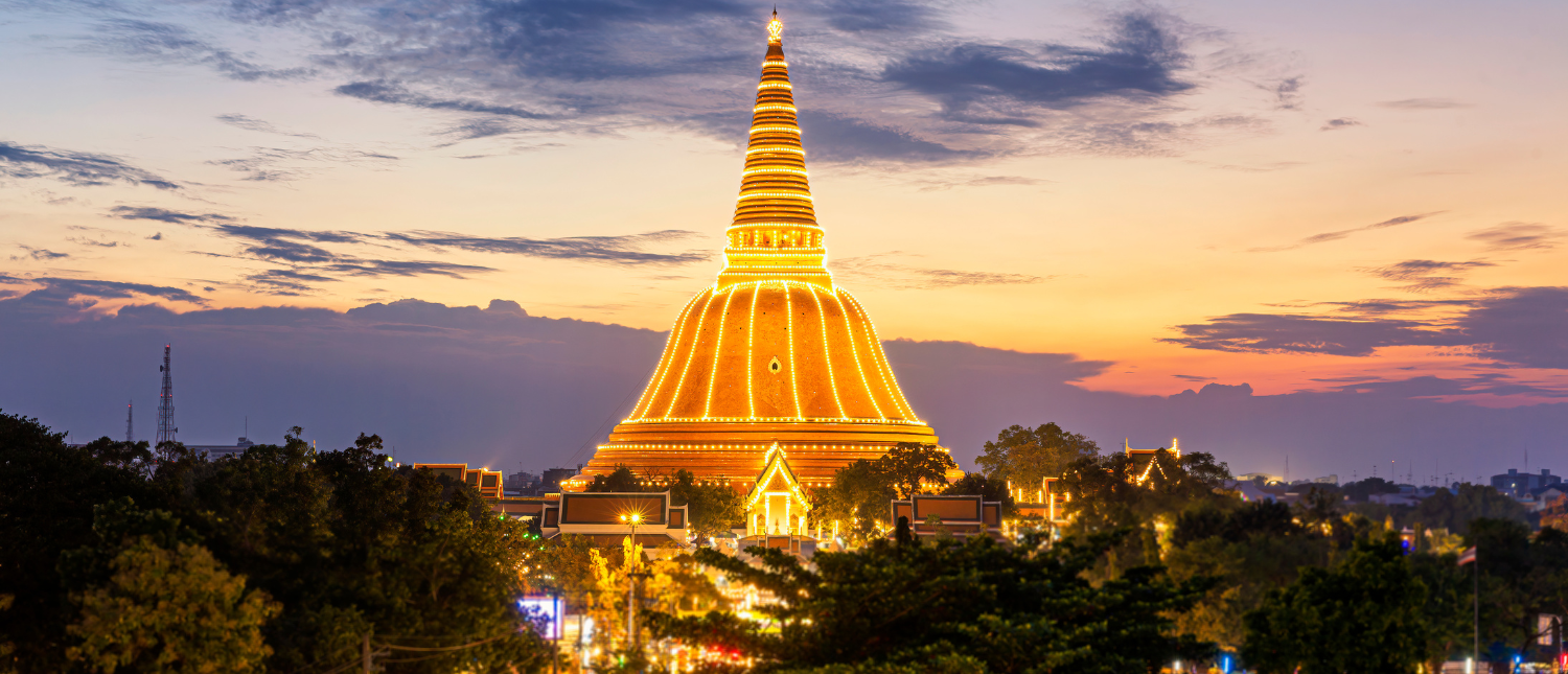 Golden Phra Pathom Chedi stupa illuminated at sunset in Nakhon Pathom