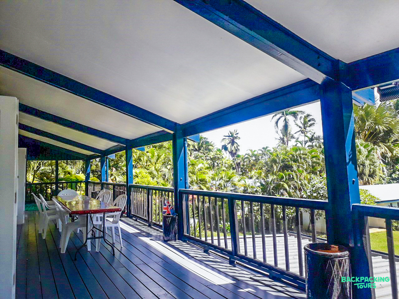 Spacious blue and white veranda with outdoor seating, overlooking lush tropical palm trees in Fiji.