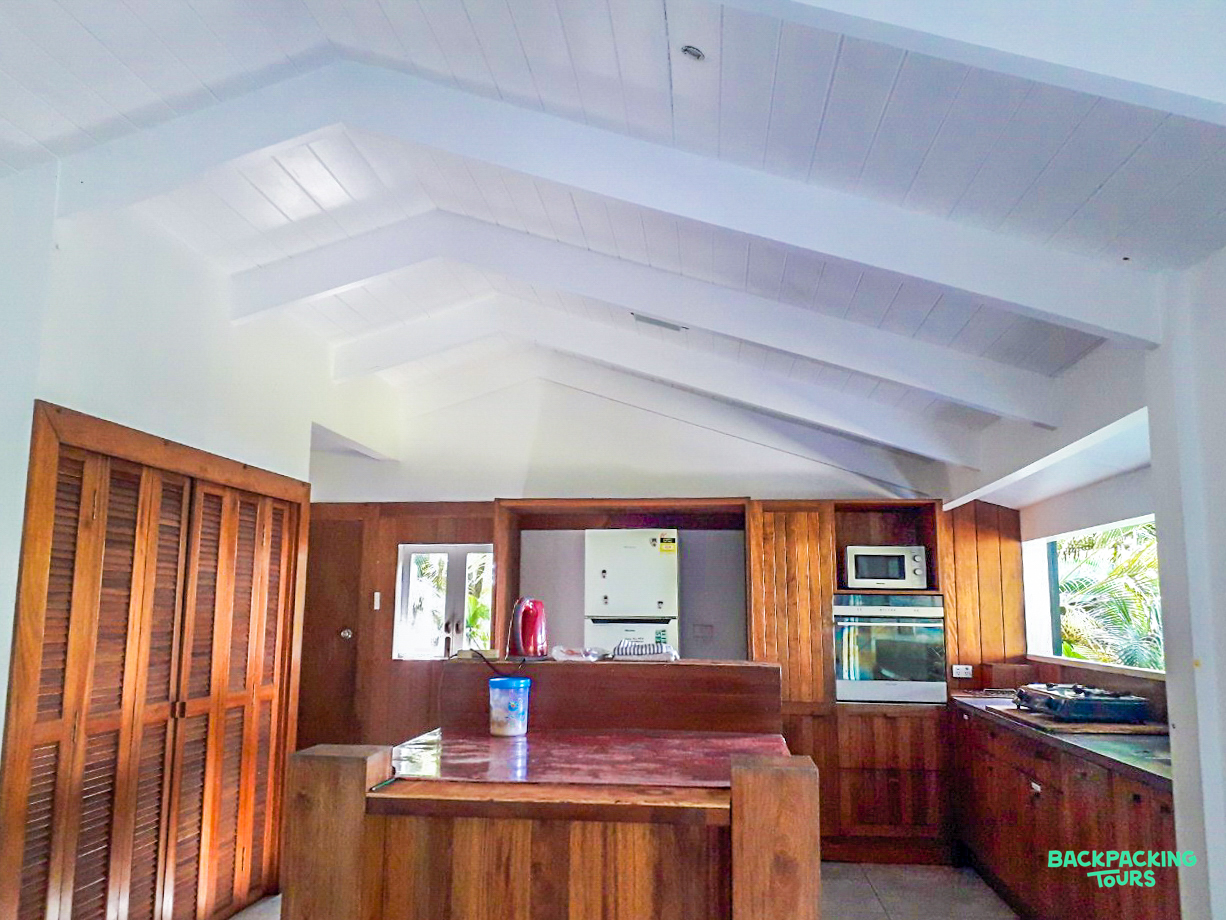 A welcoming common area with a wooden kitchen, ample counter space, and a bright vaulted ceiling.