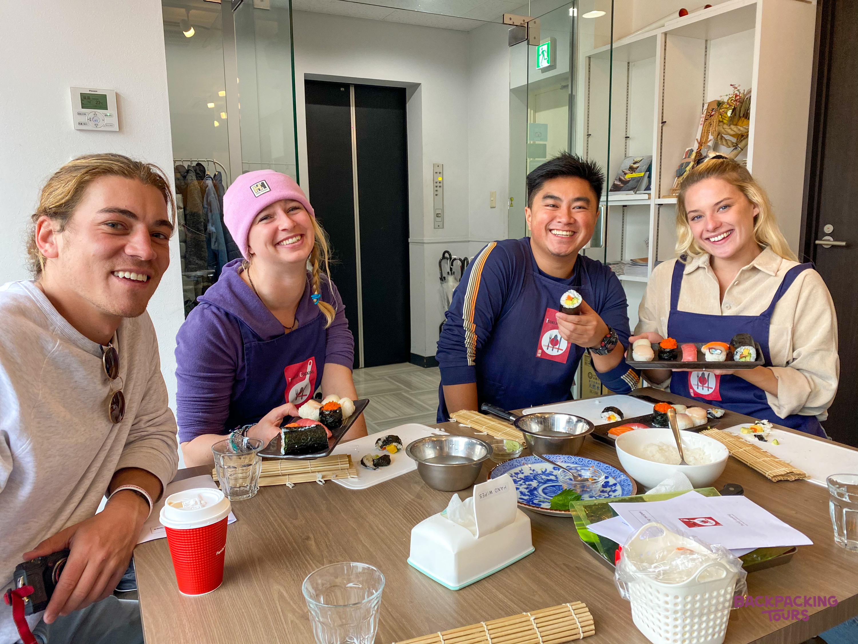 Group of travellers enjoying a hands-on sushi making class together in Tokyo.