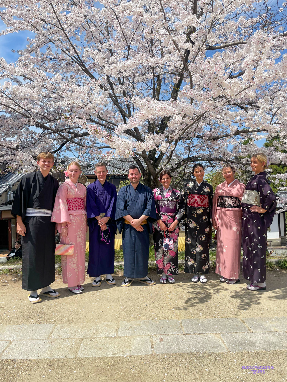 Backpackers dressed in traditional kimono, exploring Kyoto's historic streets.