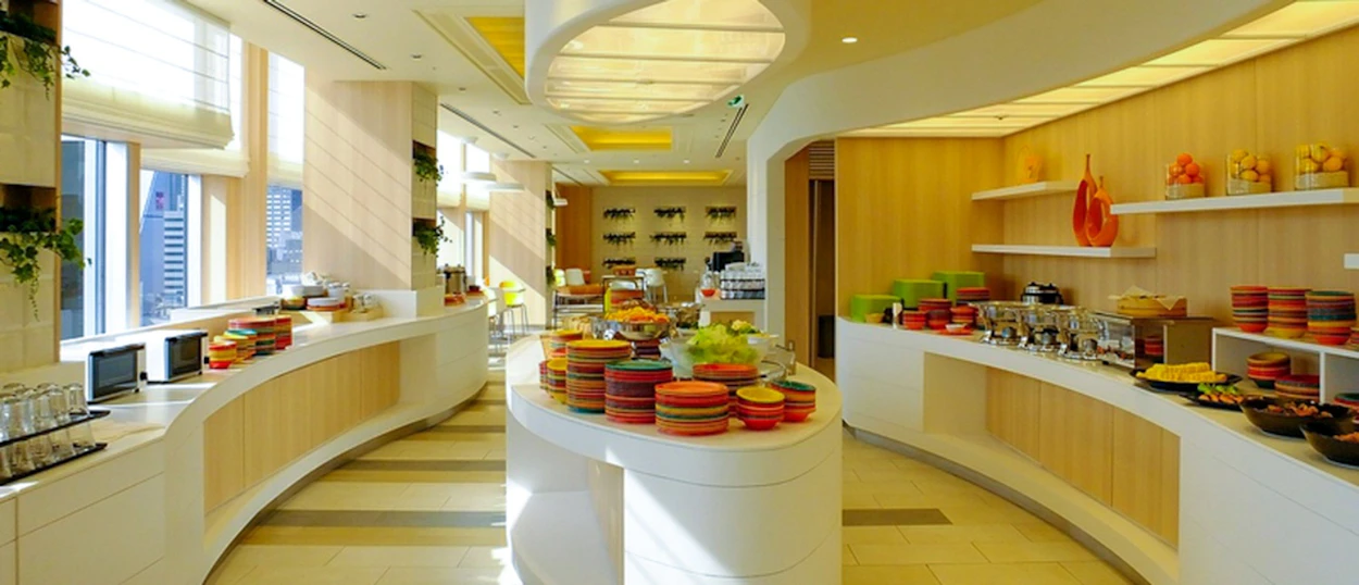 A bright, modern breakfast buffet with various food items and serving dishes in a hotel in Osaka.