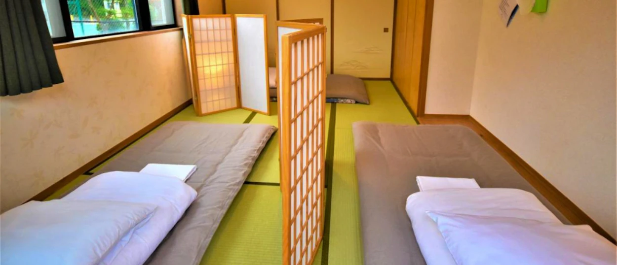 Cosy traditional Japanese guesthouse room in Hakone with two futon beds on tatami mats.