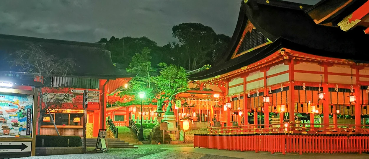 Senso-ji Temple in Tokyo, beautifully illuminated at night with vibrant red buildings and glowing lanterns.