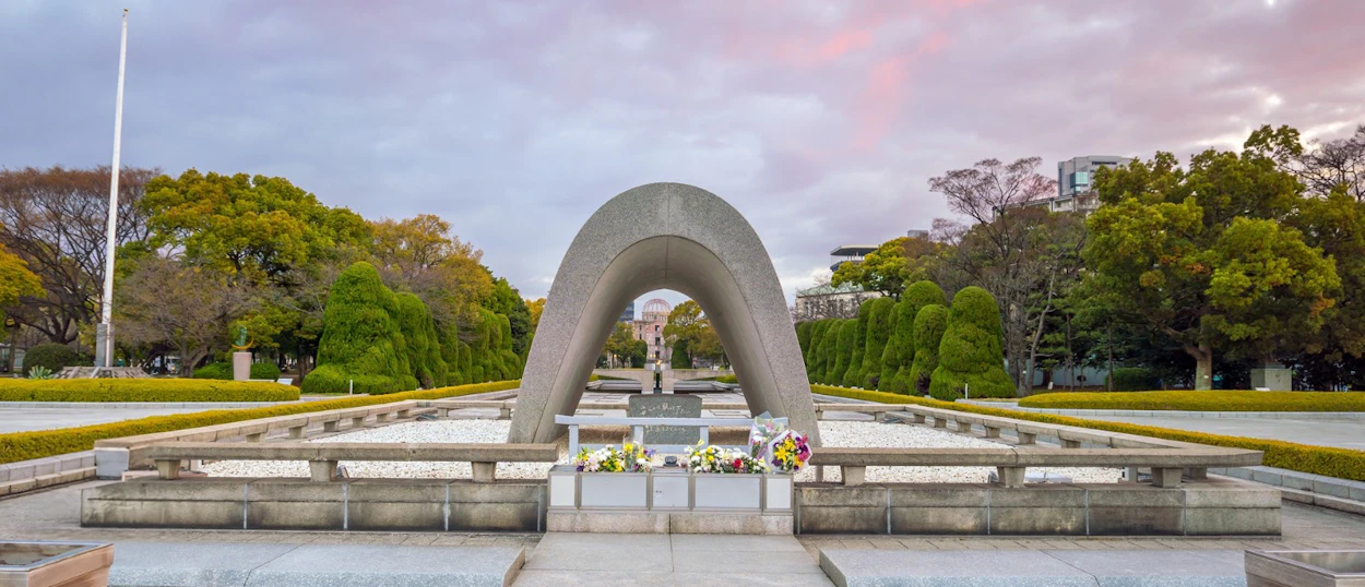 A solemn view of the Cenotaph and Atomic Bomb Dome in Hiroshima Peace Memorial Park.