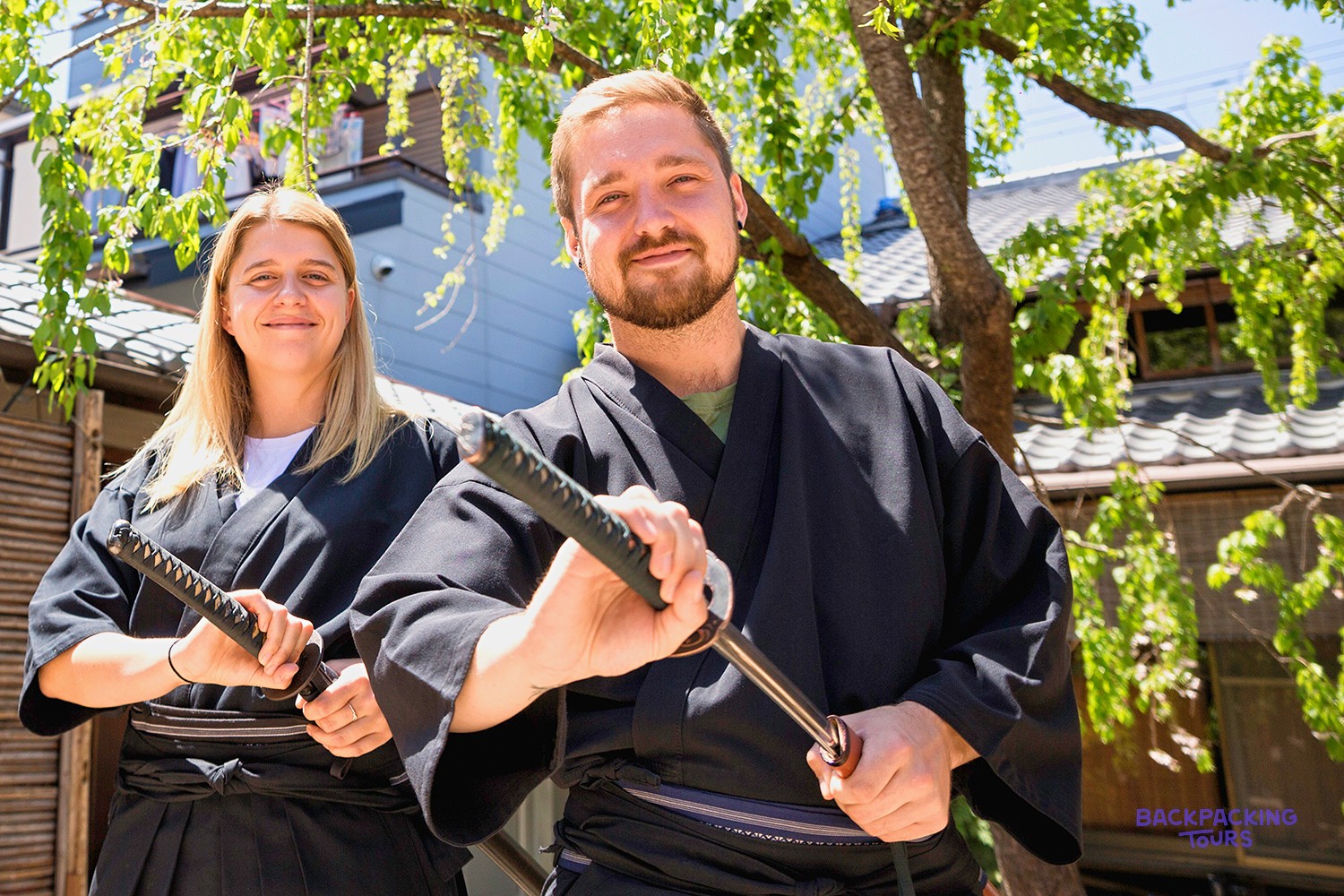 Two travellers dressed in samurai robes holding swords in Kyoto