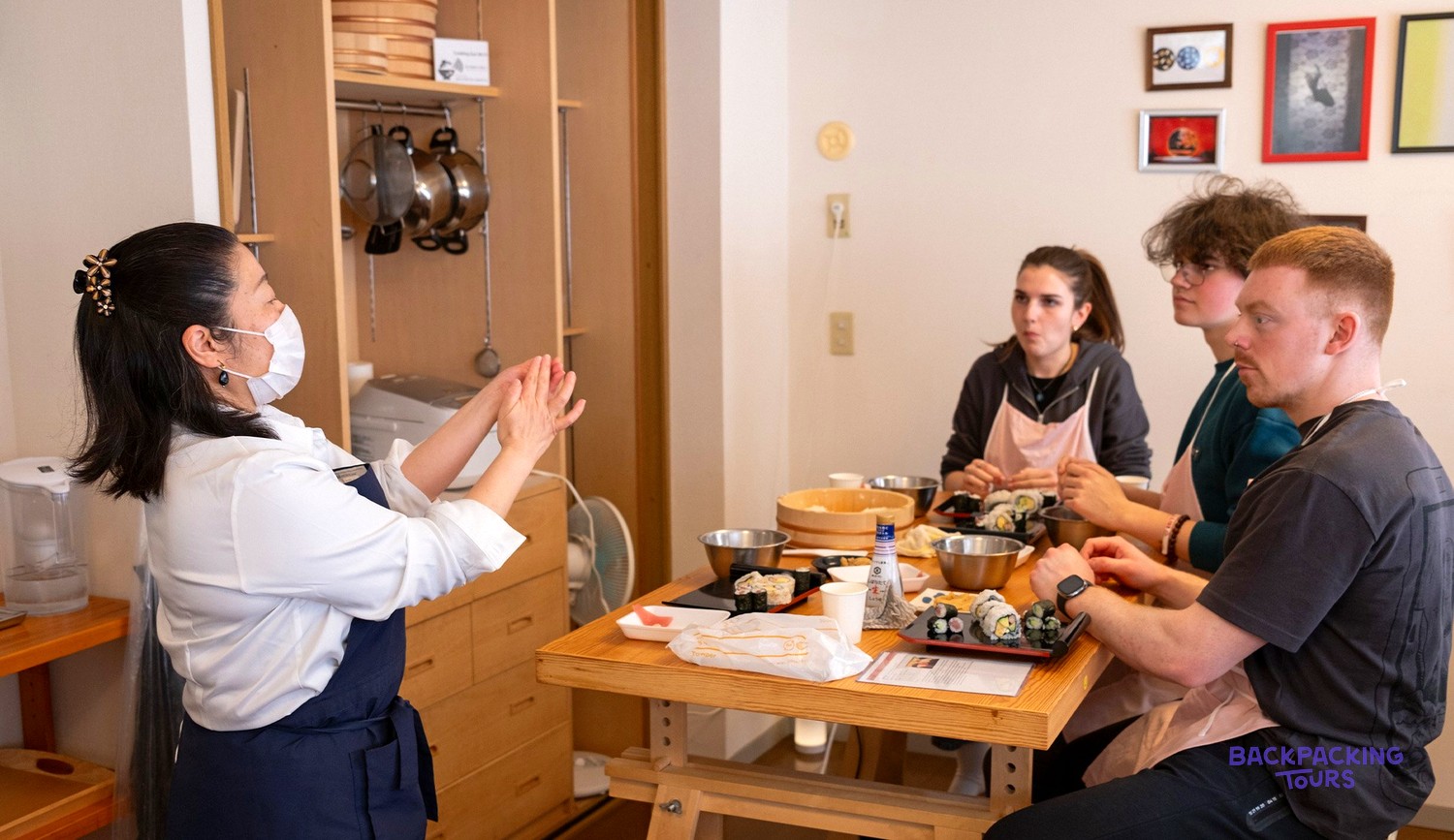 Sushi master teaching travellers to hand-roll their own sushi in Tokyo