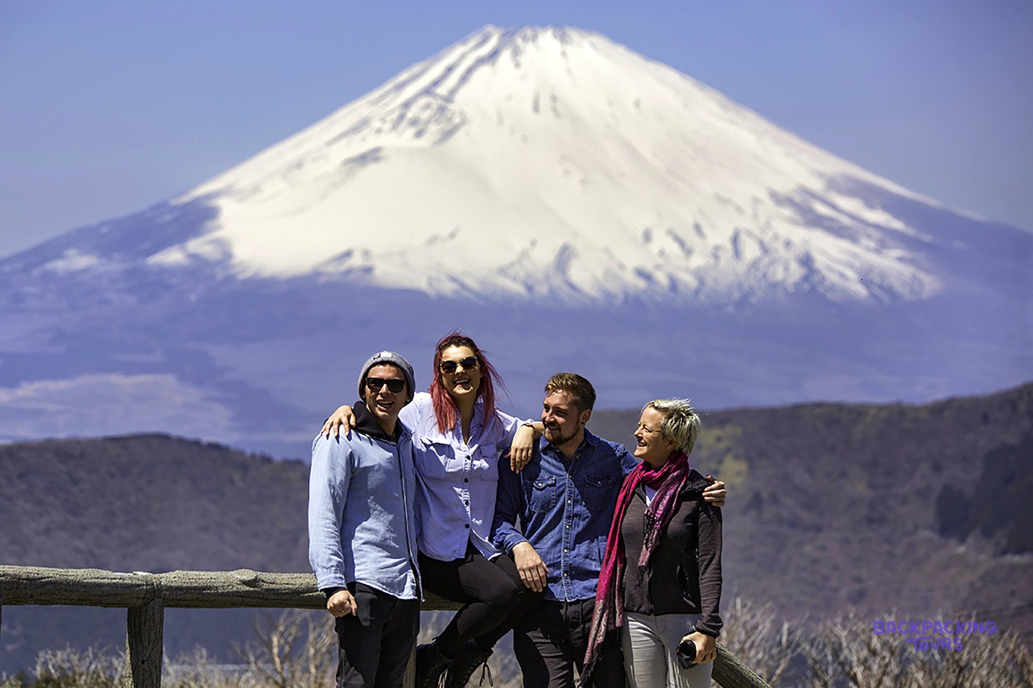Group posing in front of snow-capped Mount Fuji from Hakone