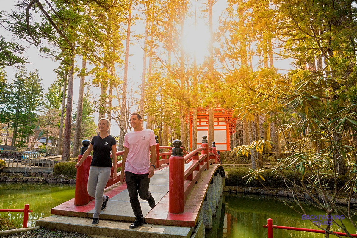 Travellers crossing the red bridge into Koyasan