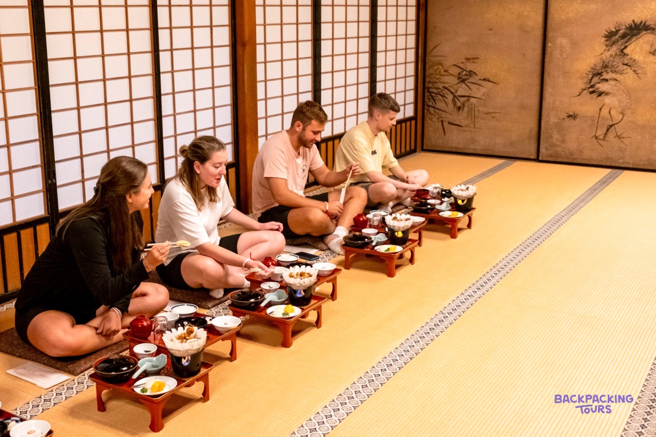 Group kneeling on tatami mats for the monks' traditional dinner