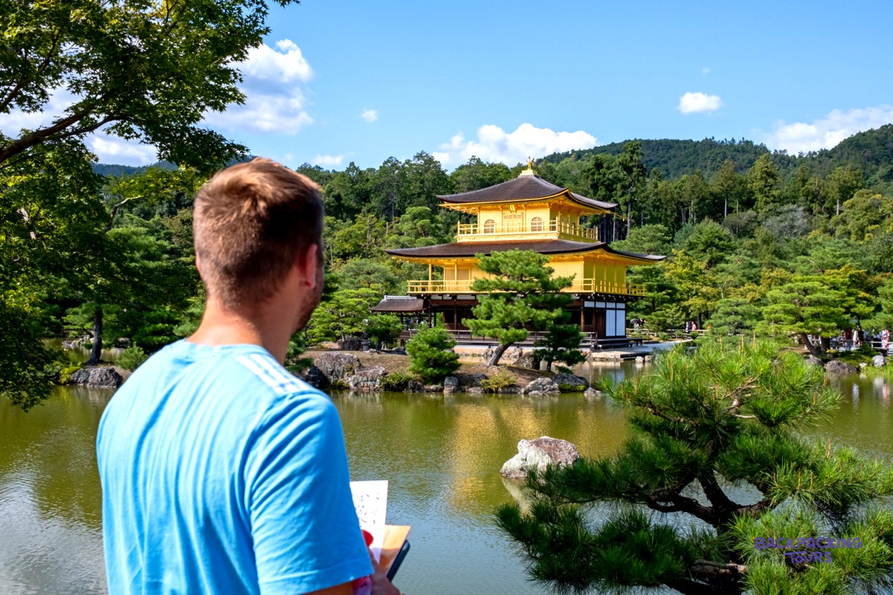 Traveller looking across the water to Kyoto's Golden Pavilion