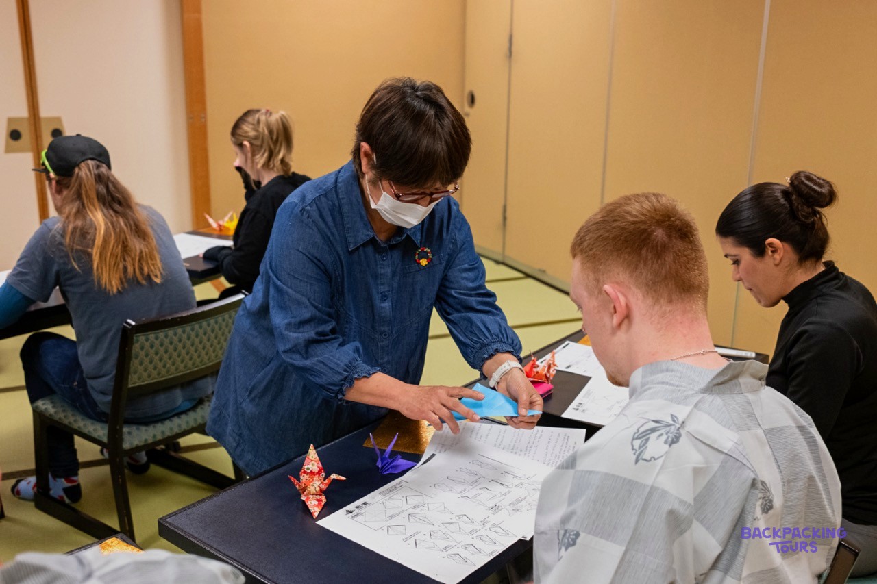 Local artisan teaching a traveller the art of origami in Nagano