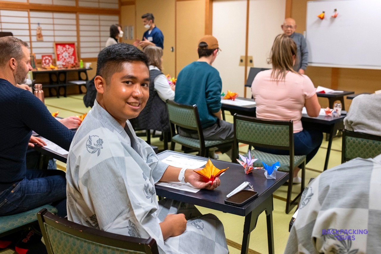 Traveller folding origami paper during a class in Nagano