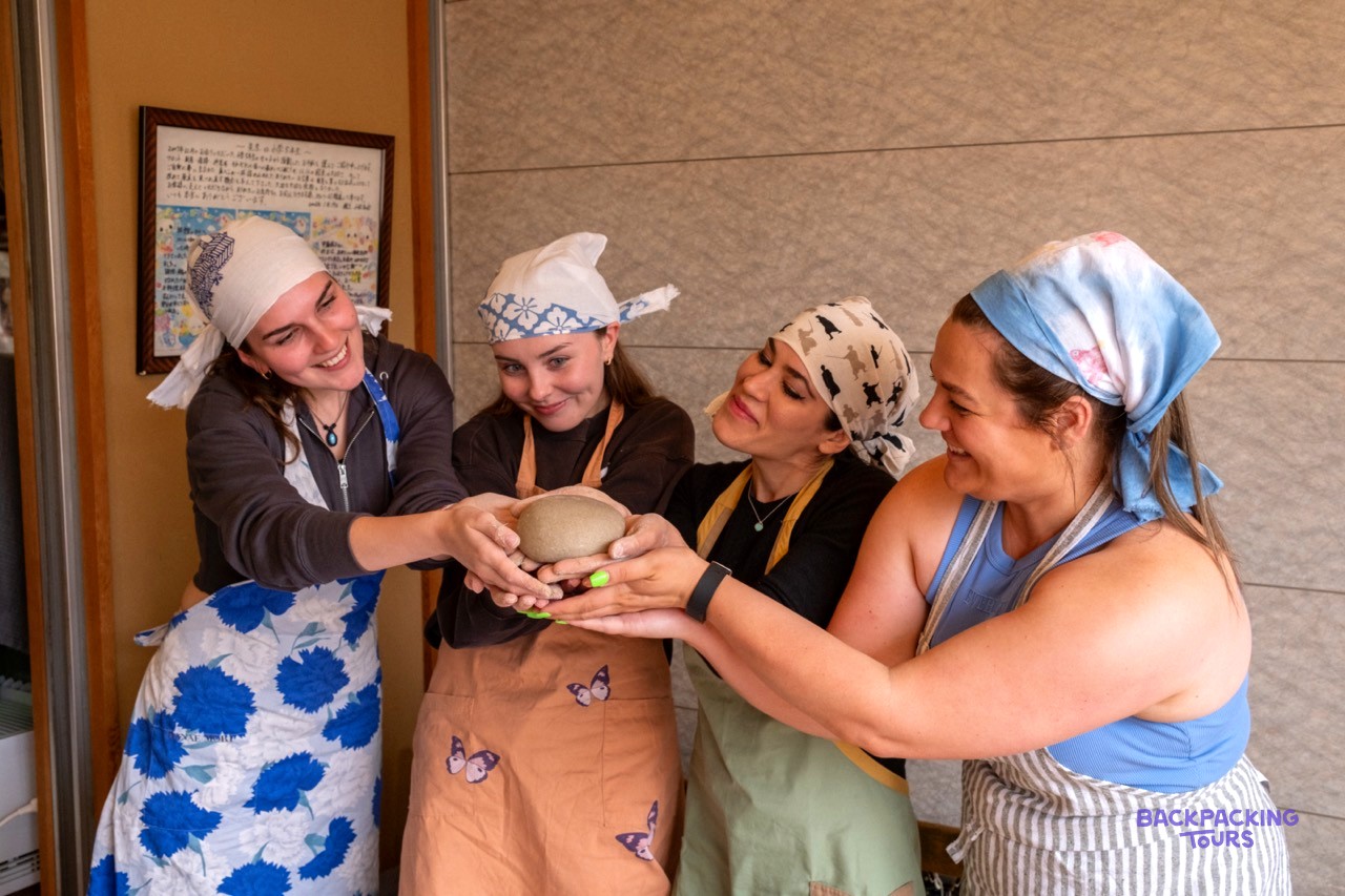 Travellers in headscarves shaping soba dough in a Nagano cooking class