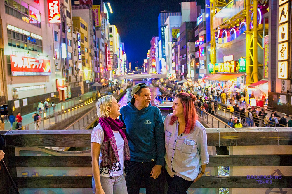 Travellers taking in the neon of Osaka's Dotonbori canal