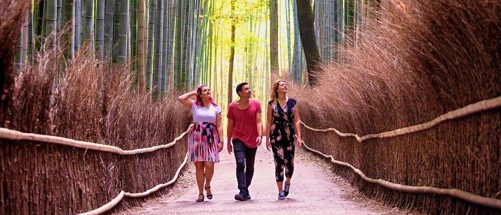 Couple walking the fenced path through Kyoto's Arashiyama Bamboo Forest