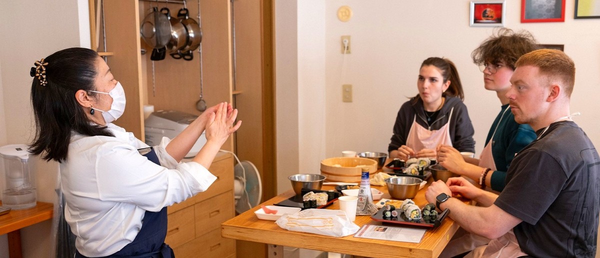 Sushi master teaching travellers to hand-roll their own sushi in Tokyo