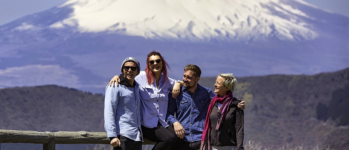 Group posing in front of snow-capped Mount Fuji from Hakone
