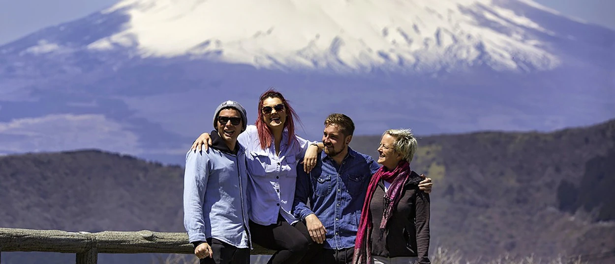 Group posing in front of snow-capped Mount Fuji from Hakone